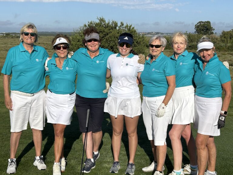 a group of lady golfers looking at the camera